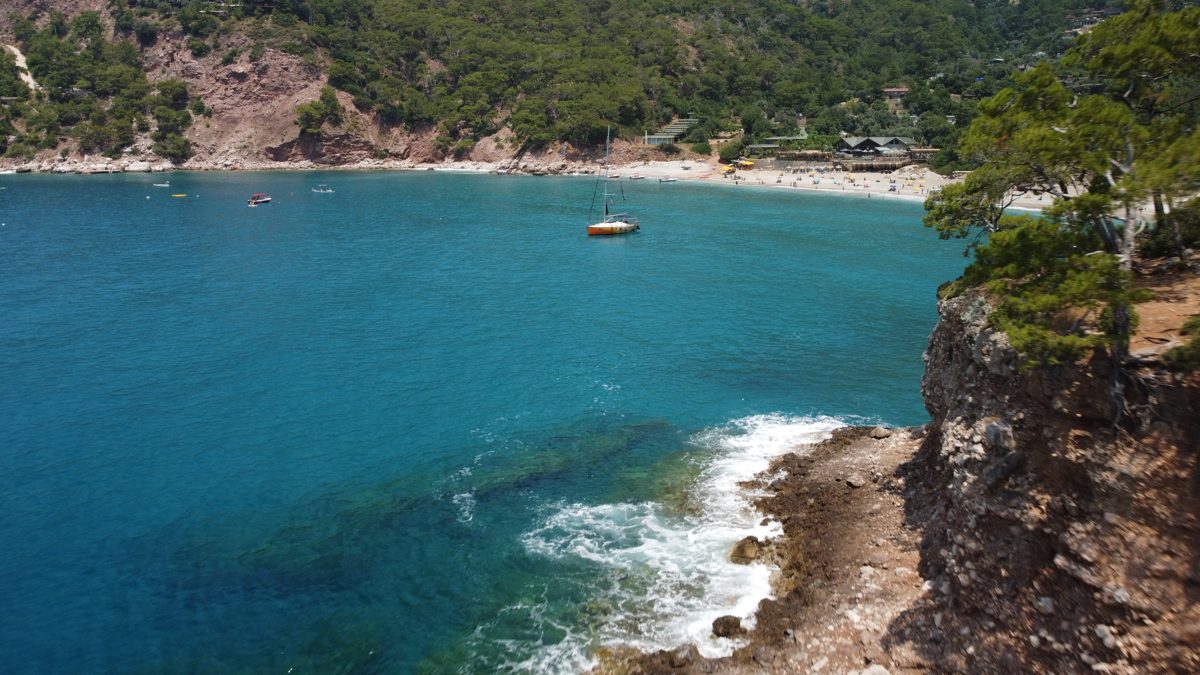Cliffs and pine trees above a turquoise bay