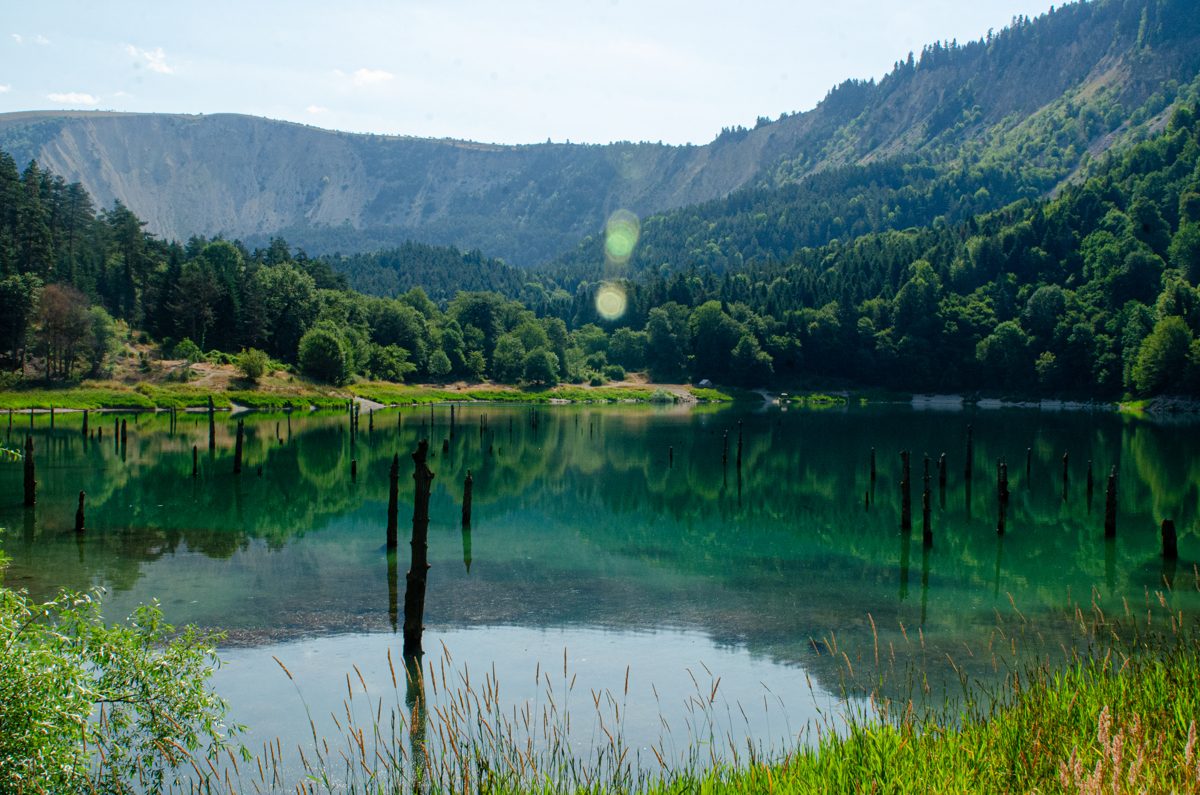 Still mountain lake reflecting a ridge and forest